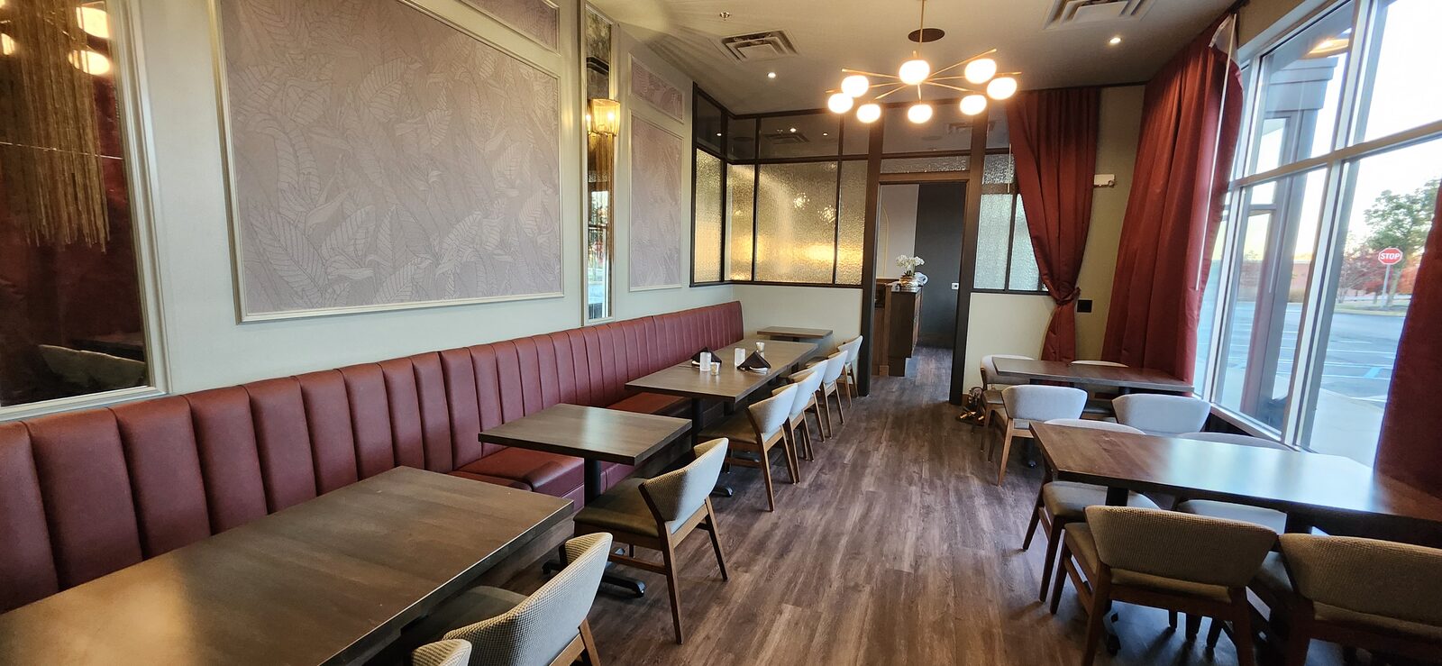 Finished restaurant dining room with a long channeled banquette, ready for opening night